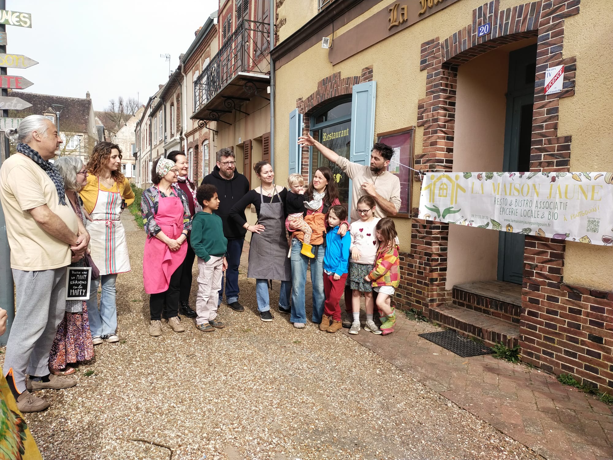 la nouvelle équipe de la maison jaune et ses clients devant la porte principale lors de l'inauguration de mars 2026
